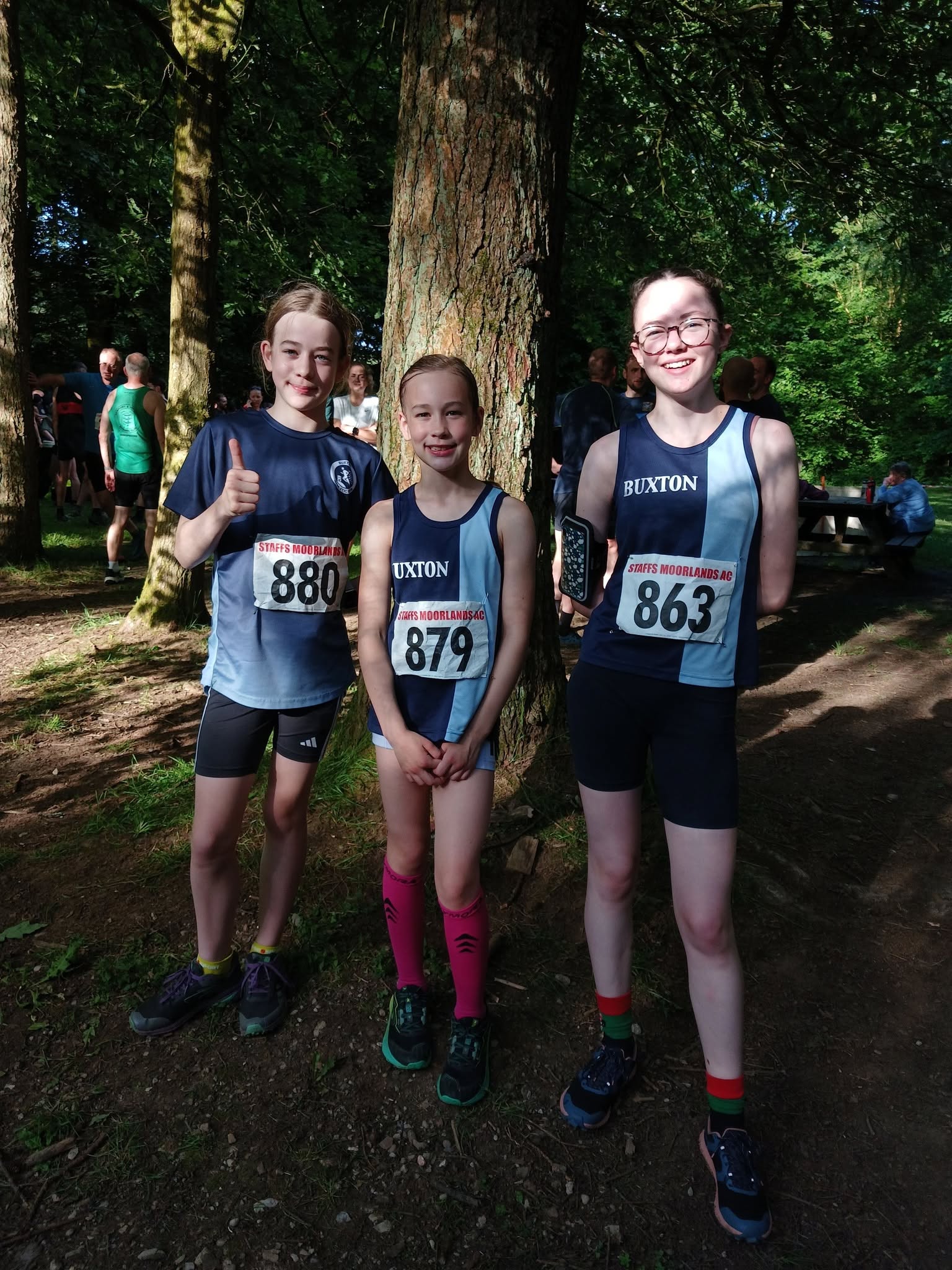 Three junior athletes ready for a woodland race