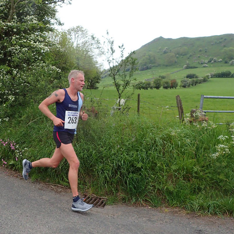 A Buxton AC runner racing through the countryside