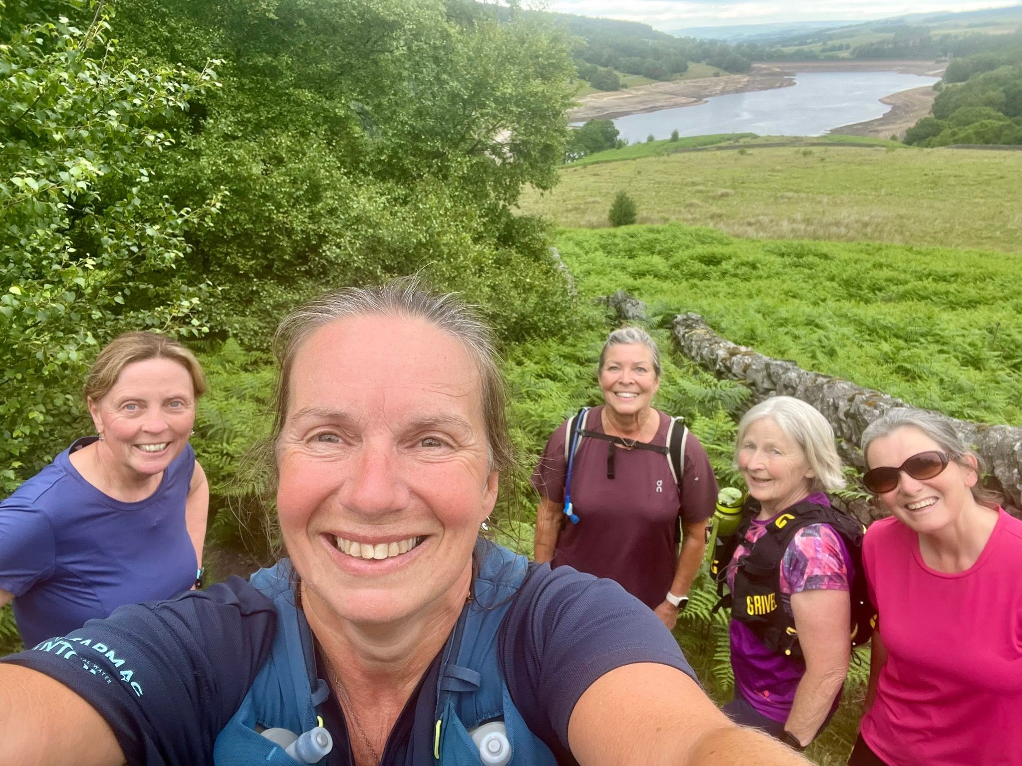 Friends on a summer trail run above a reservoir